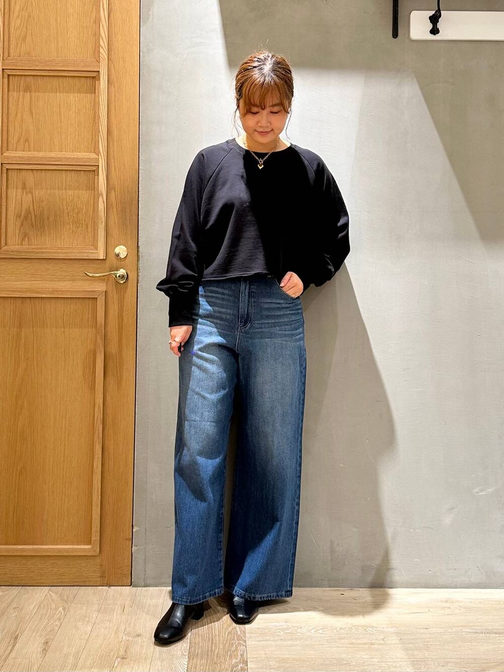 ブラック系のTシャツ/カットソー、ブルー系のデニムパンツ、ベージュ系のショルダーバッグを着用したレディースの秋コーディネートの2枚目の写真