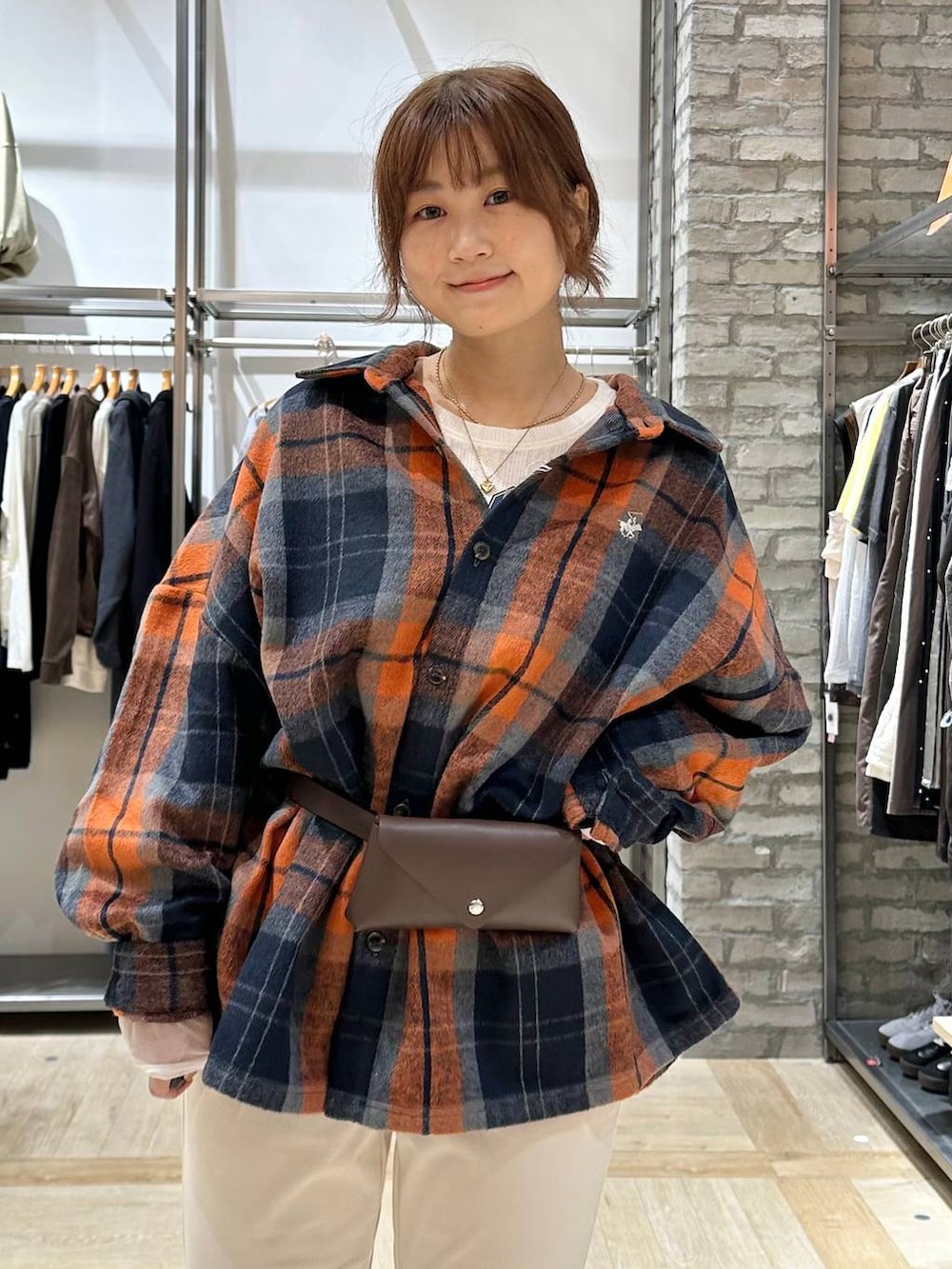 ブラウン系のブーツ、ホワイト系のTシャツ/カットソー、オレンジ系のシャツ/ブラウスを着用したレディースの秋コーディネートの4枚目の写真