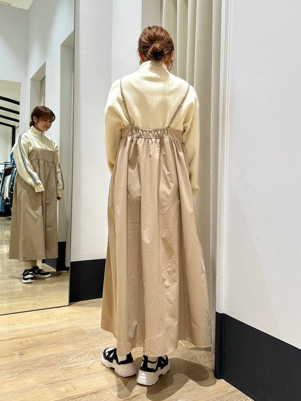 ベージュ系のワンピース、ブラック系のその他アウター、ホワイト系のスニーカーを着用したレディースの冬コーディネートの7枚目の写真