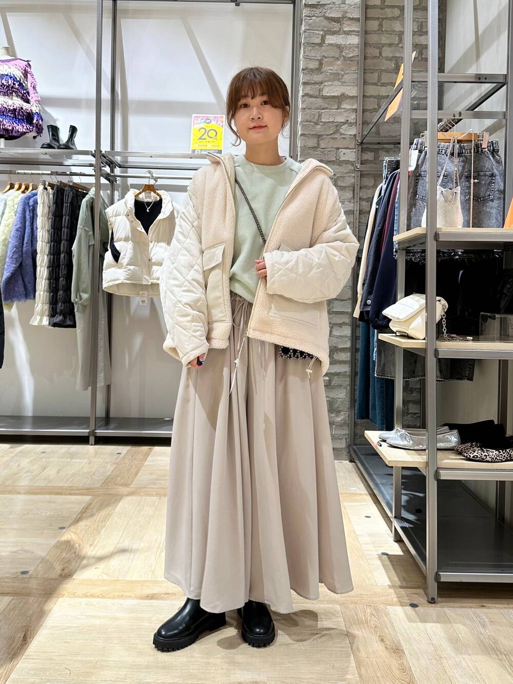 グリーン系のニット/セーター、ブラック系のブーツ、ベージュ系のその他パンツを着用したレディースの秋コーディネートの5枚目の写真