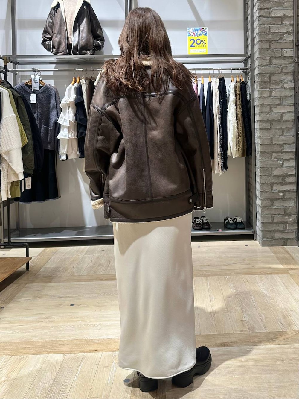 ホワイト系のスカート、ブラウン系のニット/セーター、ブラウン系のその他アウターを着用したレディースの秋コーディネートの3枚目の写真