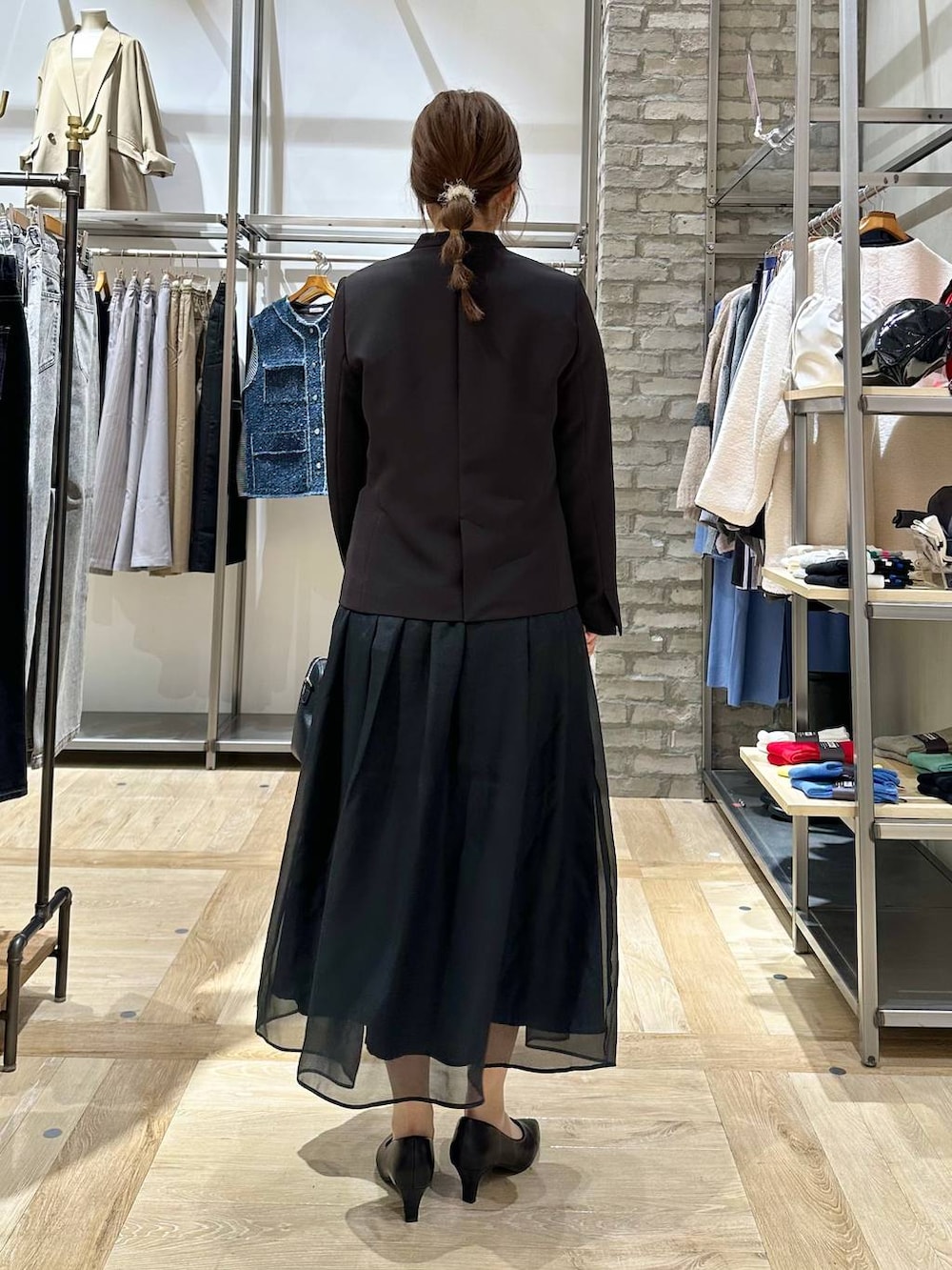 ブラック系のスカート、ブラック系のスーツジャケット、ホワイト系のTシャツ/カットソーを着用したレディースの冬コーディネートの4枚目の写真