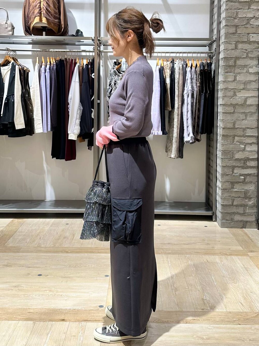 グレー系のニット/セーター、イエロー系のスニーカー、ブラック系のショルダーバッグを着用したレディースの秋コーディネートの3枚目の写真