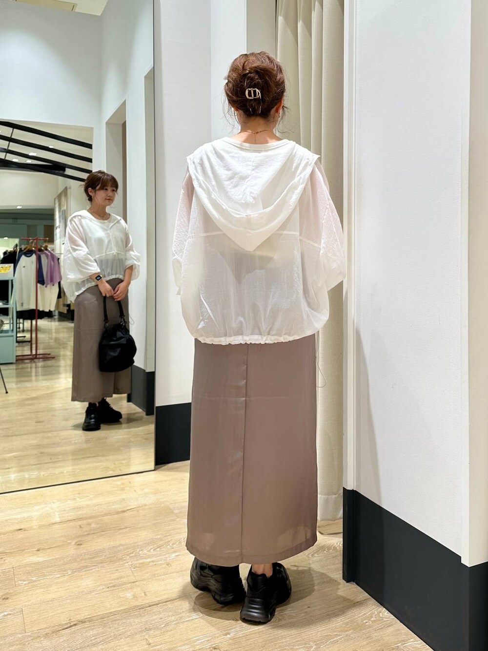 ブラック系のショルダーバッグ、ブラック系のスニーカー、ホワイト系のタンクトップを着用したレディースの秋コーディネートの4枚目の写真