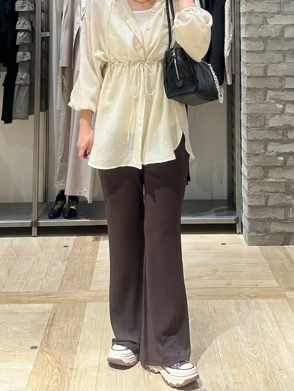ブラック系のボストンバッグ、ホワイト系のシャツ/ブラウス、ブラウン系のその他パンツを着用したレディースの春コーディネートの5枚目の写真