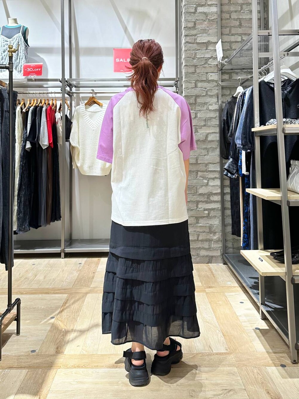 ブラック系のスカート、ブラック系のショルダーバッグ、ブラック系のサンダルを着用したレディースの夏コーディネートの4枚目の写真