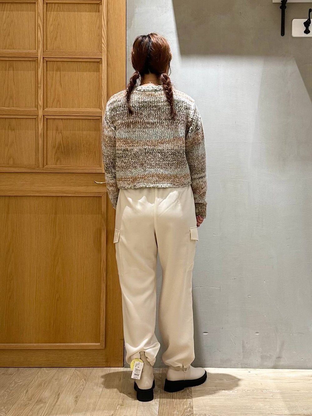 ブラウン系のノーカラーコート、ホワイト系のブーツ、ホワイト系のショルダーバッグを着用したレディースの秋コーディネートの7枚目の写真