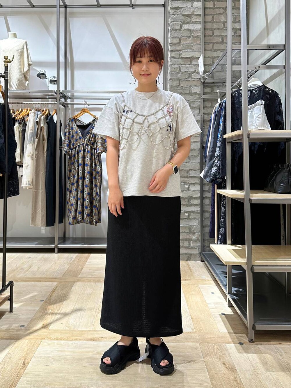 ブラック系のサンダル、シルバー系のベスト、ブラック系のスカートを着用したレディースの夏コーディネートの2枚目の写真