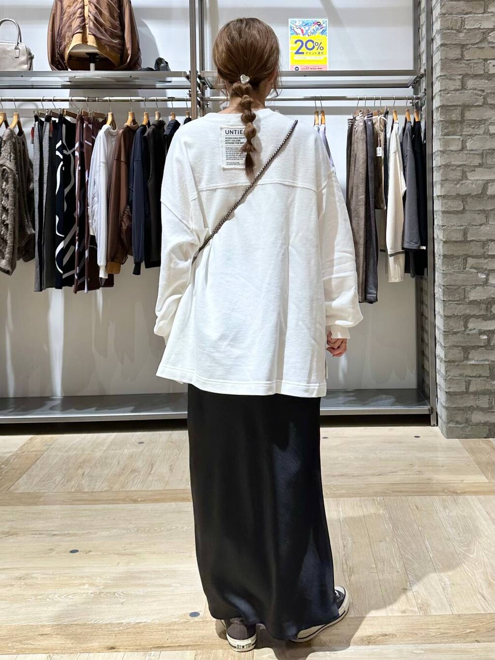 ブラック系のショルダーバッグ、ブラック系のスカート、ホワイト系のTシャツ/カットソーを着用したレディースの秋コーディネートの4枚目の写真