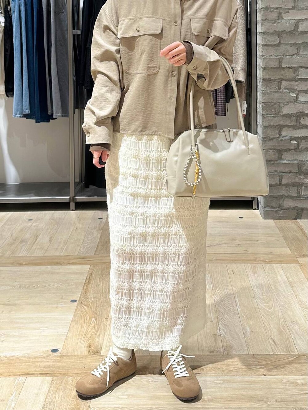 ホワイト系のスカート、ベージュ系のシャツ/ブラウス、ホワイト系のボストンバッグを着用したレディースの冬コーディネートの5枚目の写真