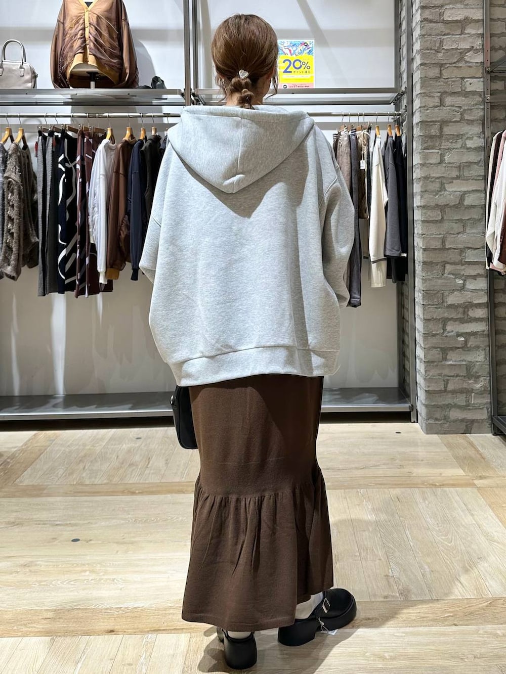 ブラウン系のスカート、ホワイト系のTシャツ/カットソー、ブラック系のサンダルを着用したレディースの秋コーディネートの4枚目の写真