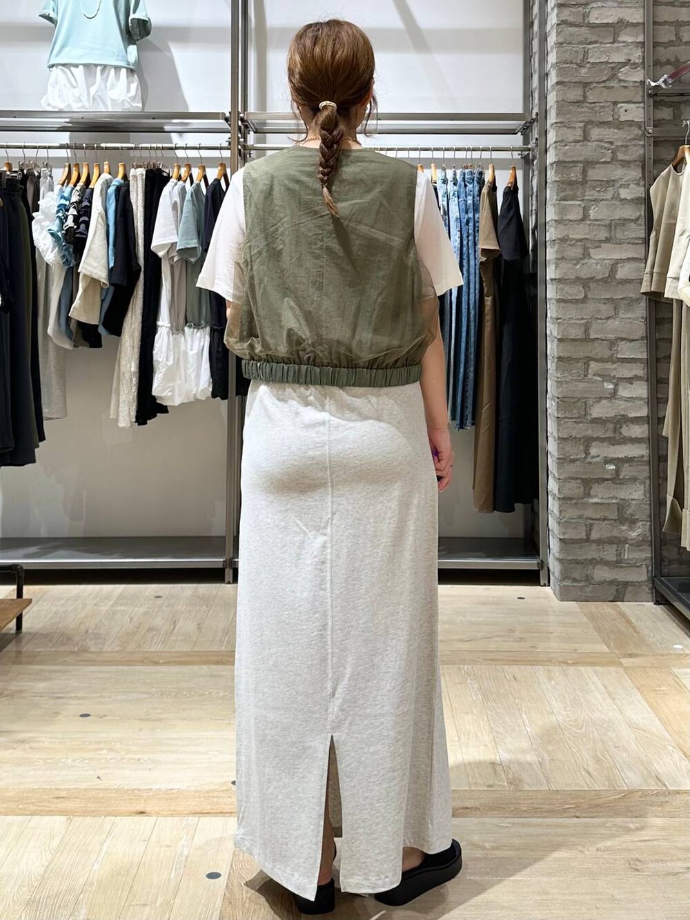 ブラック系のサンダル、グリーン系のその他アウター、グレー系のスカートを着用したレディースの夏コーディネートの3枚目の写真