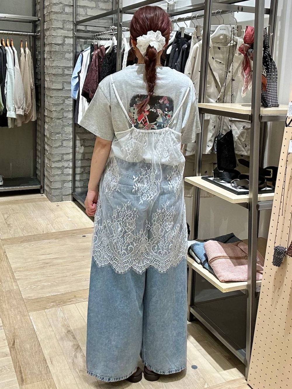 ブルー系のデニムパンツ、ブラック系のトートバッグ、ブラウン系のサンダルを着用したレディースの春コーディネートの3枚目の写真
