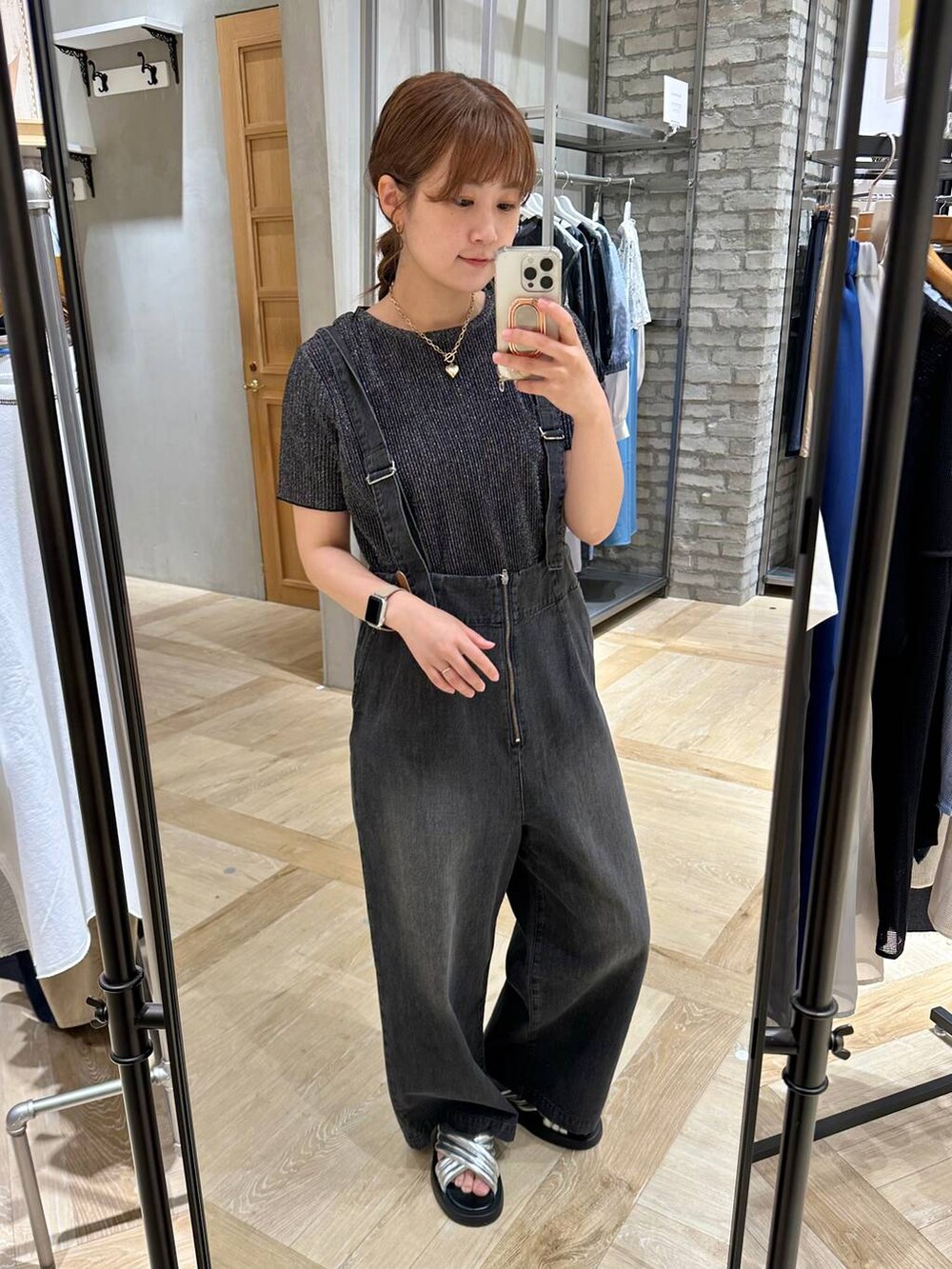 グレー系のデニムパンツ、シルバー系のサンダル、ブラック系のTシャツ/カットソーを着用したレディースの春コーディネートの2枚目の写真