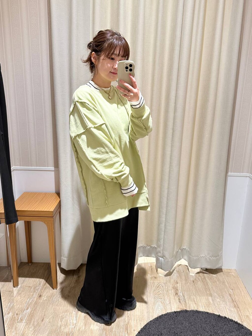 ホワイト系のニット/セーター、ブラック系のスニーカー、グリーン系のチュニックを着用したレディースの冬コーディネートの2枚目の写真