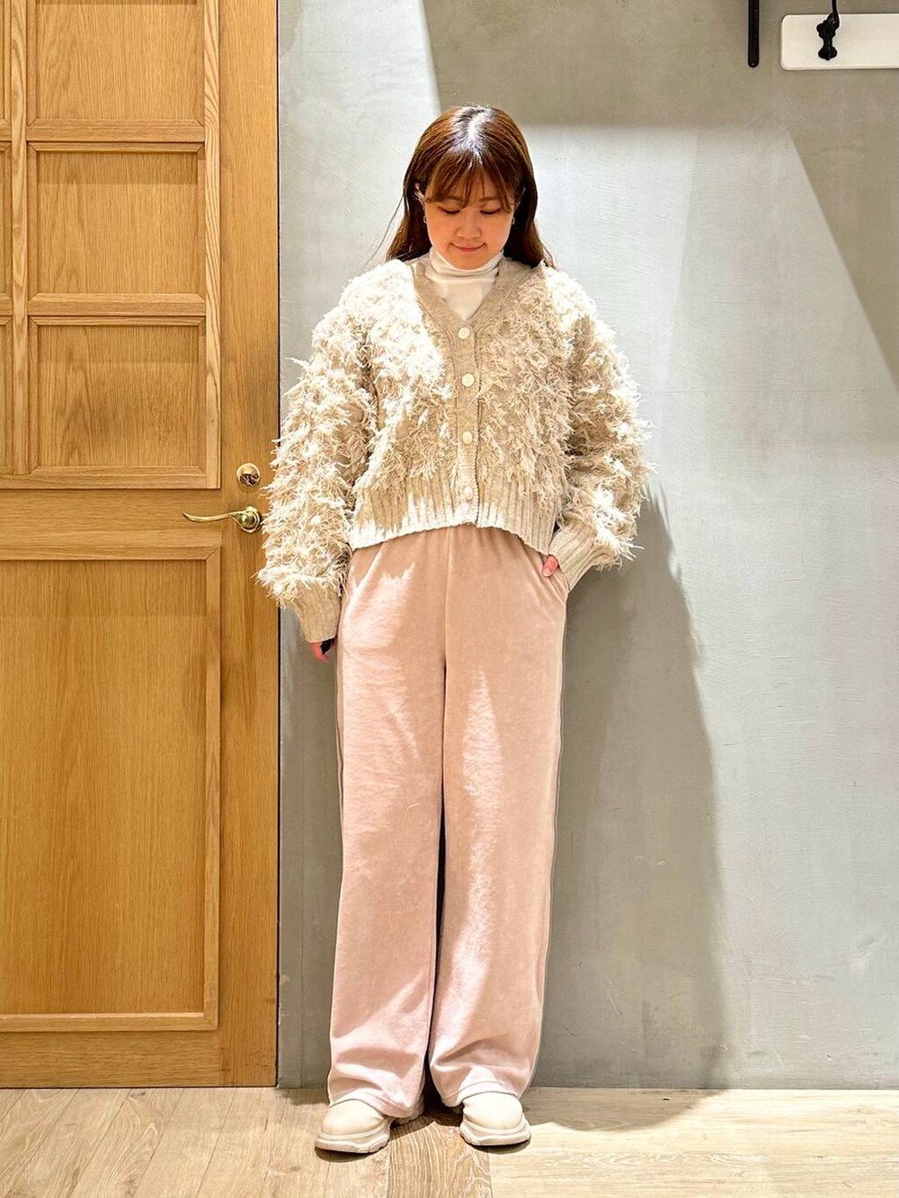 ホワイト系のTシャツ/カットソー、ホワイト系のブーツ、ホワイト系のカーディガン/ボレロを着用したレディースの冬コーディネートの2枚目の写真