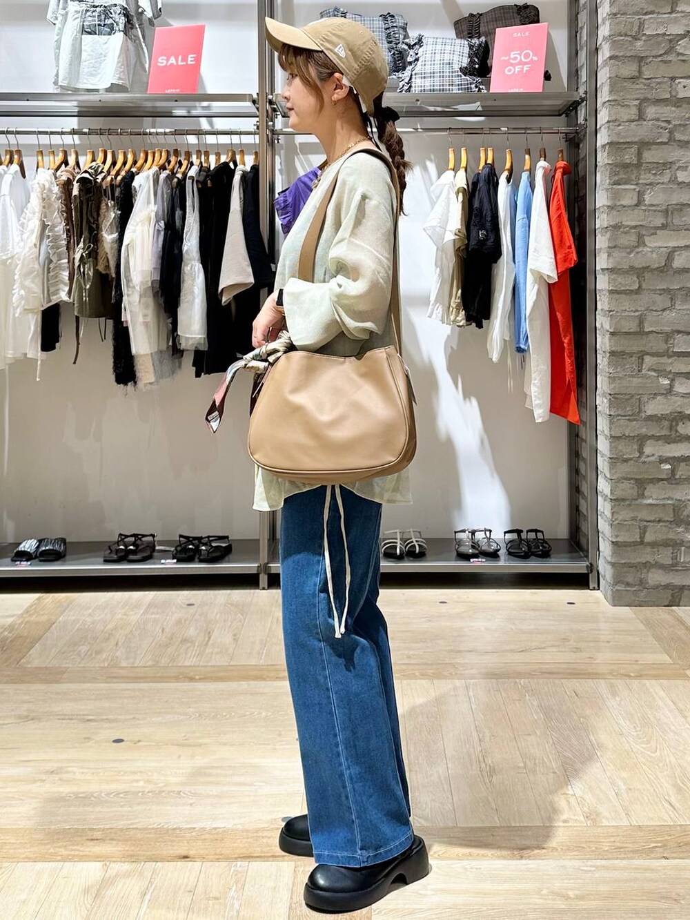 ベージュ系のショルダーバッグ、ブルー系のその他パンツ、ブラック系のサンダルを着用したレディースの秋コーディネートの2枚目の写真