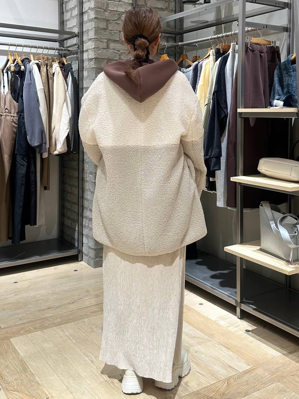 ホワイト系のブーツ、ブラウン系のニット/セーター、ホワイト系のその他アウターを着用したレディースの冬コーディネートの7枚目の写真