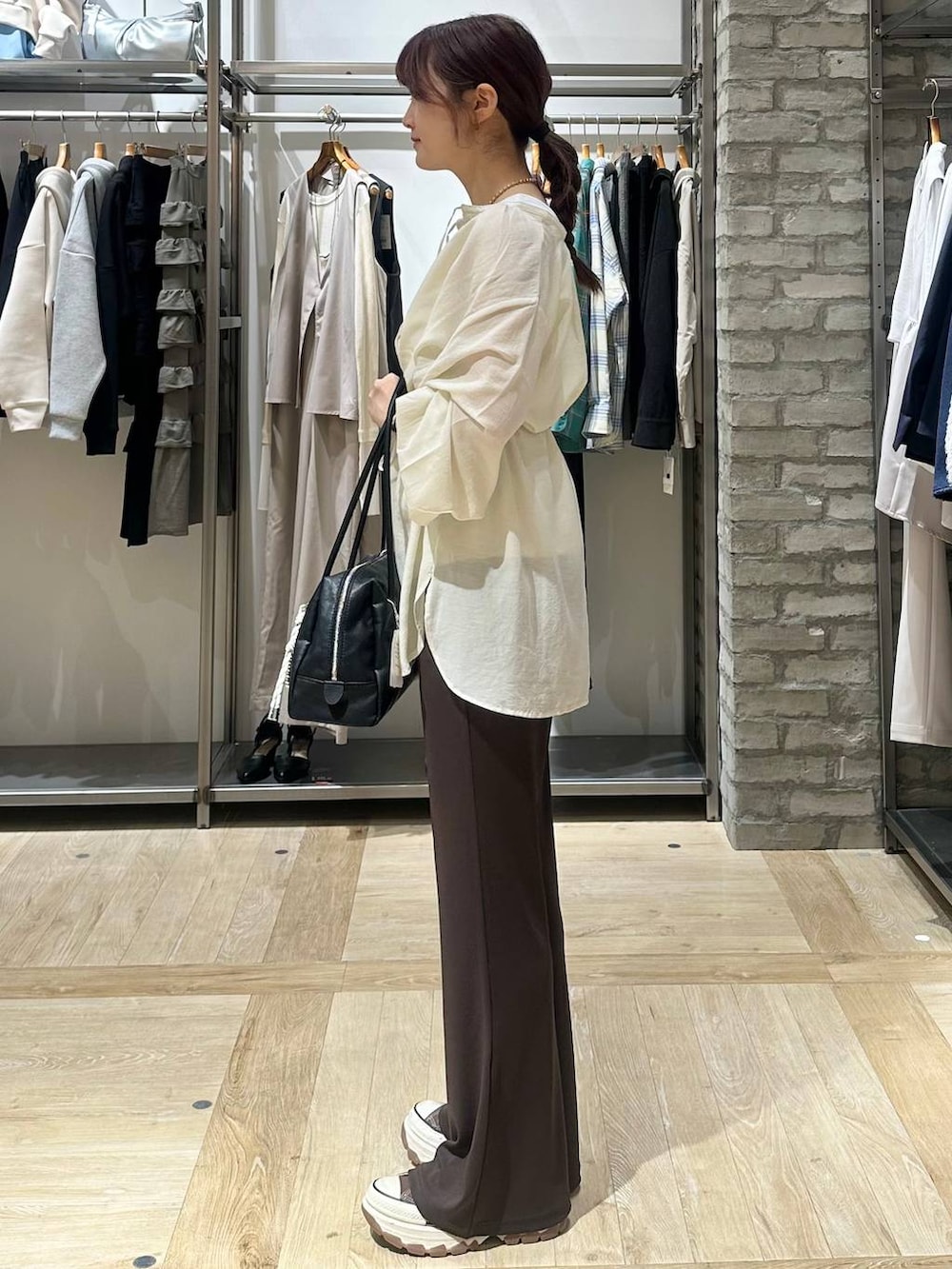 ブラック系のボストンバッグ、ホワイト系のシャツ/ブラウス、ブラウン系のその他パンツを着用したレディースの春コーディネートの2枚目の写真