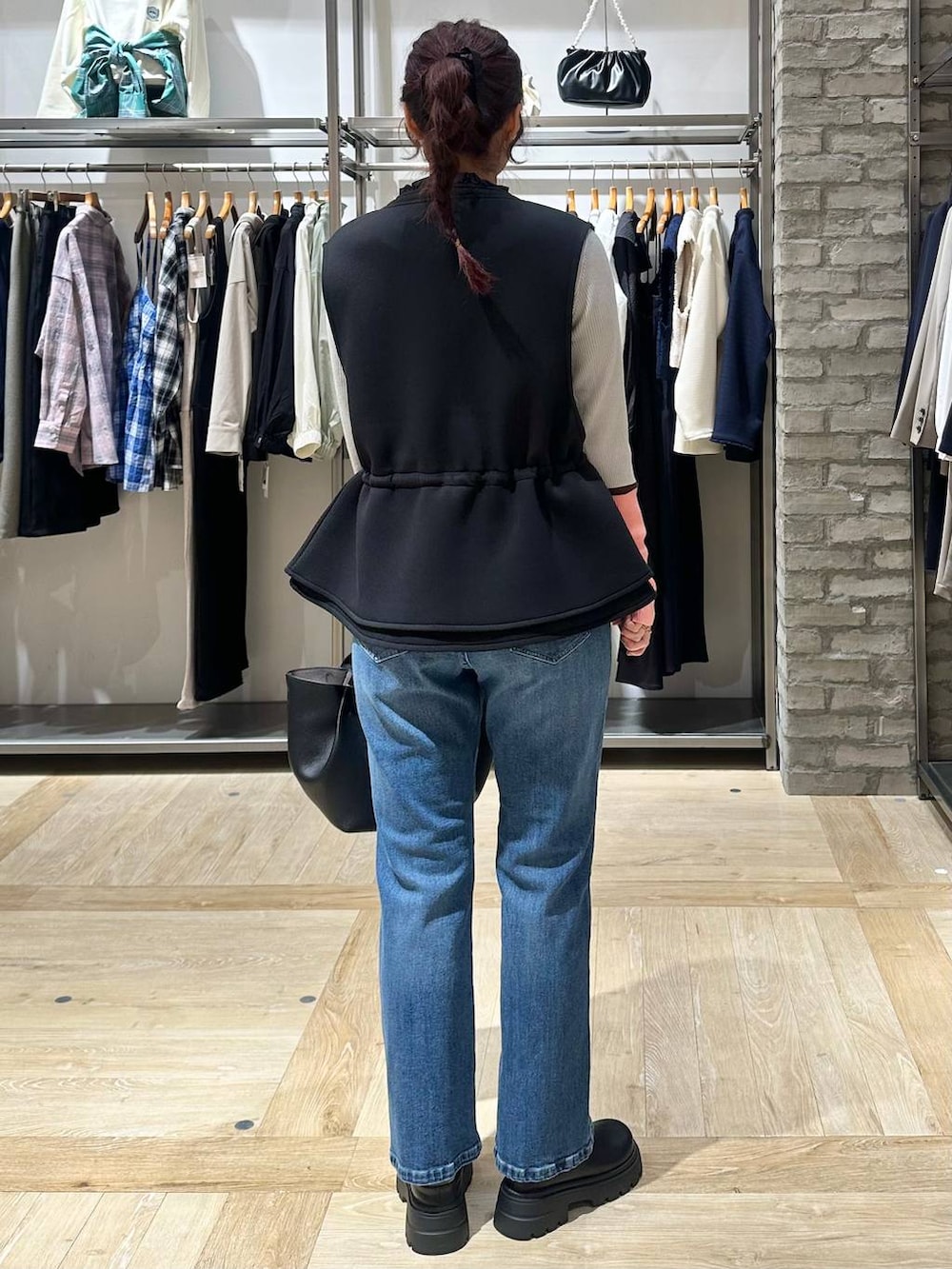 ブラック系のその他シューズ、ブラック系のトートバッグ、ブルー系のデニムパンツを着用したレディースの春コーディネートの3枚目の写真