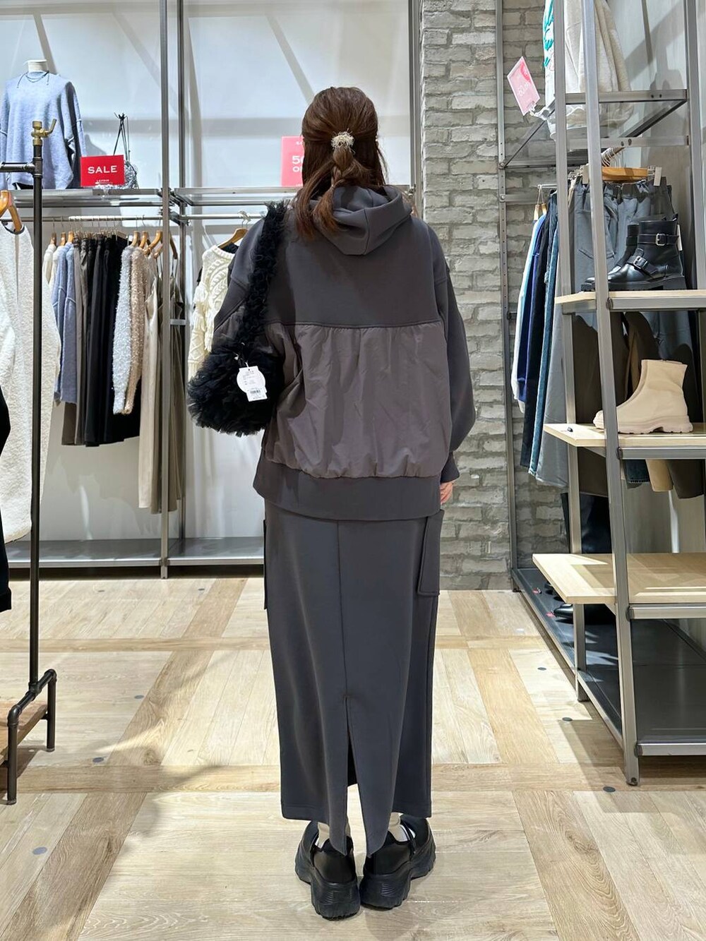 ブラック系のスニーカー、ブラック系のショルダーバッグ、グレー系のスカートを着用したレディースの冬コーディネートの3枚目の写真