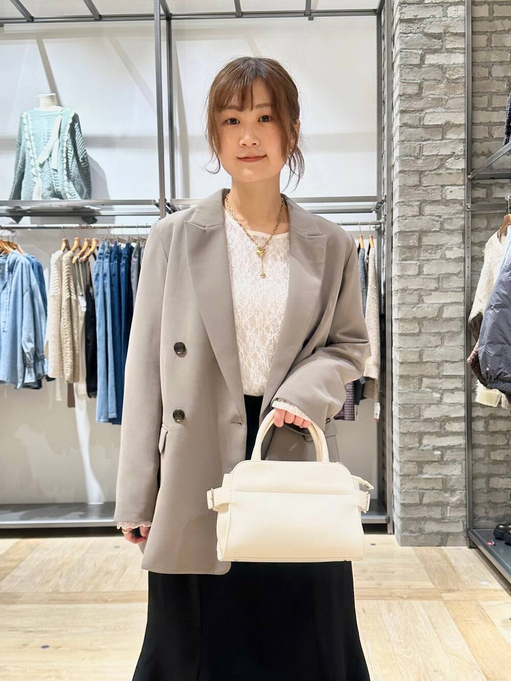 ブラウン系のテーラードジャケット、ホワイト系のTシャツ/カットソー、ブラック系のパンプスを着用したレディースの冬コーディネートの4枚目の写真