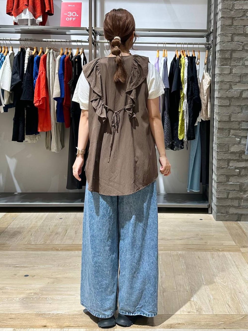ブラウン系のベスト、ブルー系のデニムパンツ、ホワイト系のTシャツ/カットソーを着用したレディースの夏コーディネートの3枚目の写真