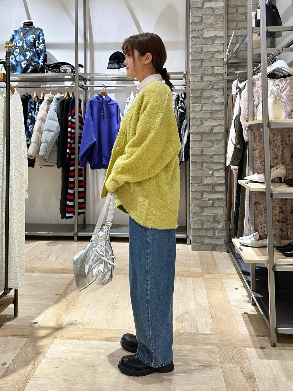 ホワイト系のTシャツ/カットソー、ブラック系のブーツ、ブルー系のデニムパンツを着用したレディースの冬コーディネートの2枚目の写真