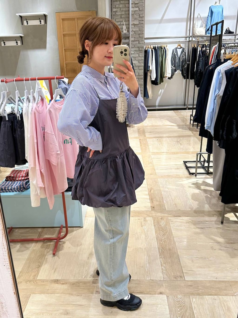 ブラック系のスニーカー、ブルー系のシャツ/ブラウス、ブルー系のデニムパンツを着用したレディースの春コーディネートの4枚目の写真