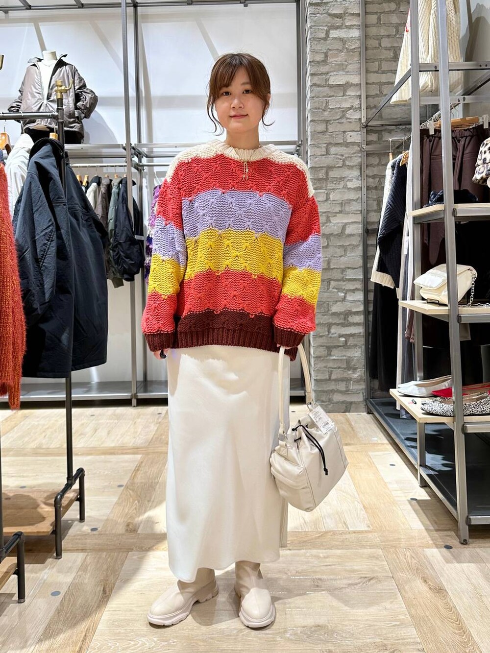 ホワイト系のスカート、ホワイト系のブーツ、ホワイト系のショルダーバッグを着用したレディースの秋コーディネートの2枚目の写真