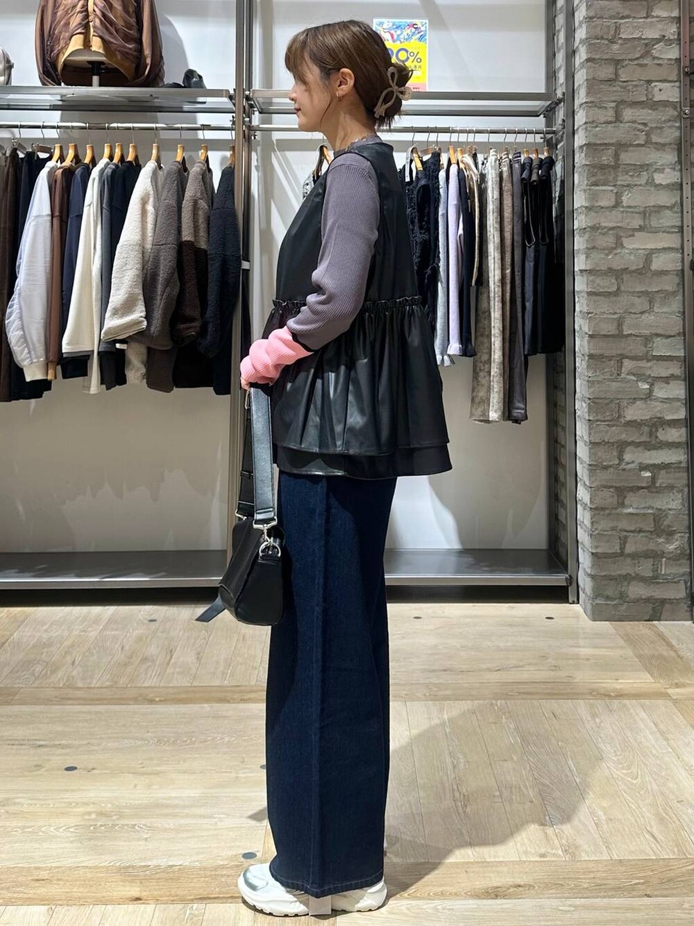 ブルー系のデニムパンツ、グレー系のニット/セーター、ホワイト系のスニーカーを着用したレディースの秋コーディネートの7枚目の写真