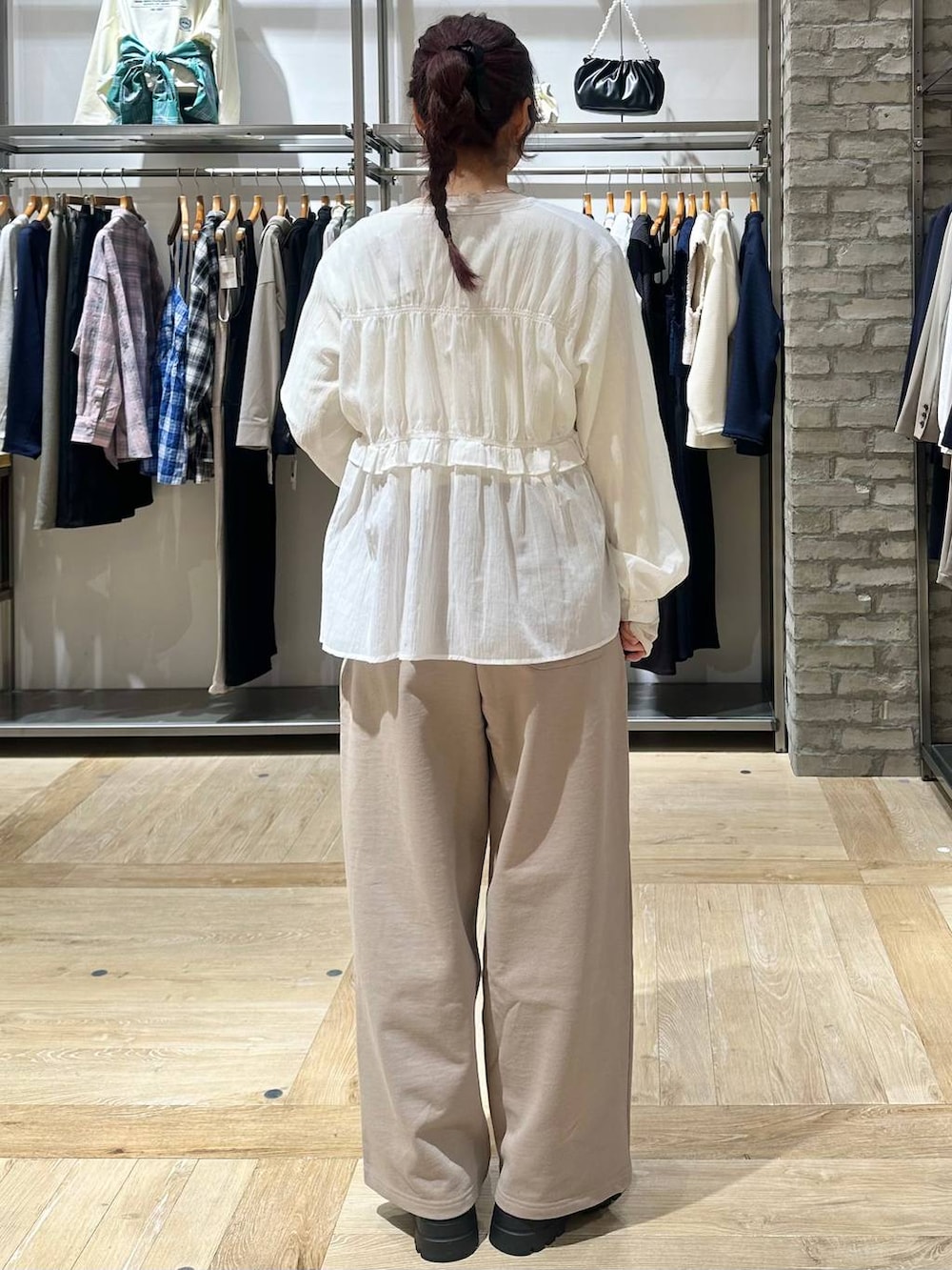 ブラウン系のボストンバッグ、ホワイト系のTシャツ/カットソー、ベージュ系のスウェットパンツを着用したレディースの春コーディネートの3枚目の写真