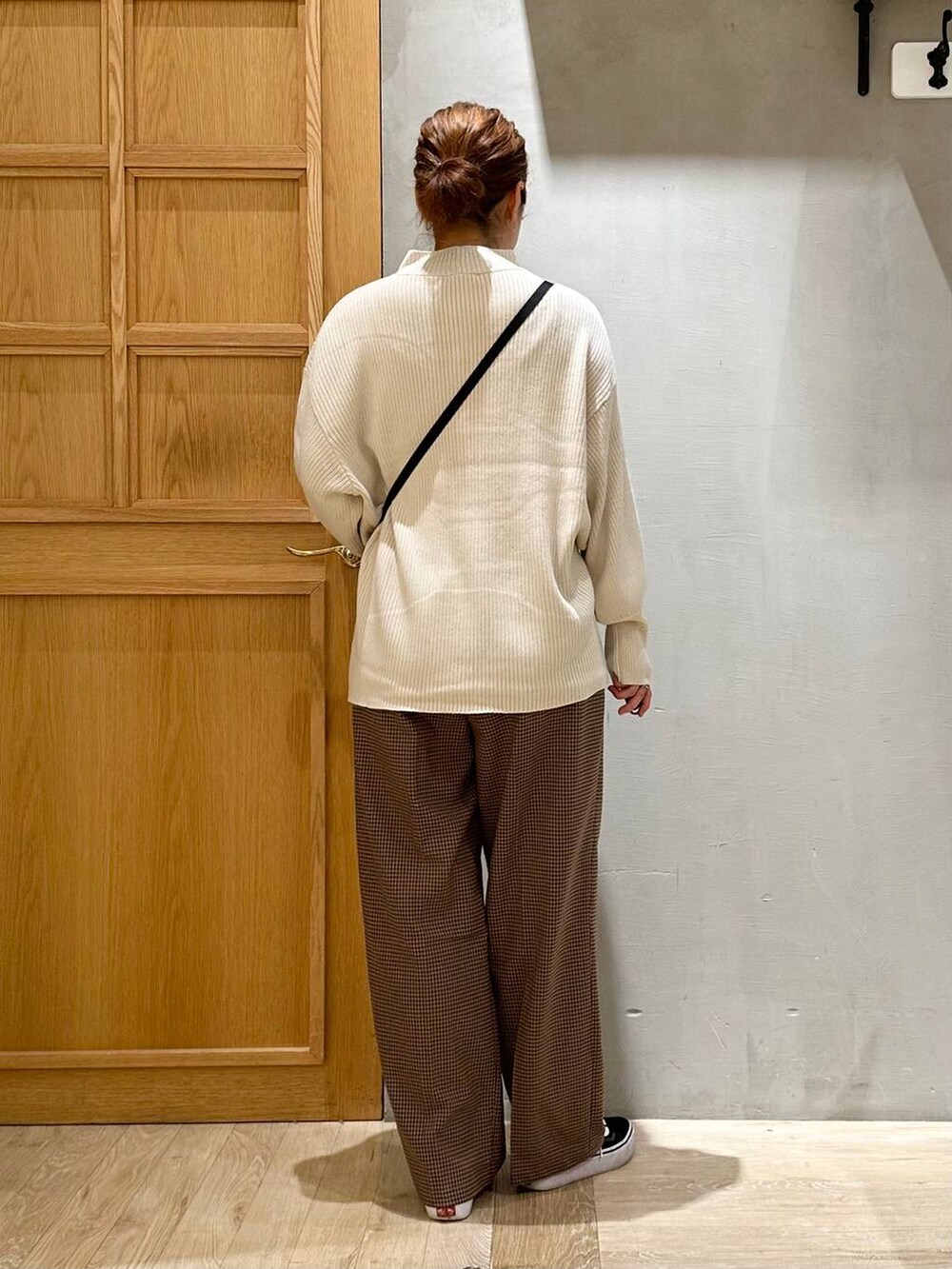 ホワイト系のニット/セーター、ブラック系のショルダーバッグ、ホワイト系のその他アウターを着用したレディースの秋コーディネートの6枚目の写真