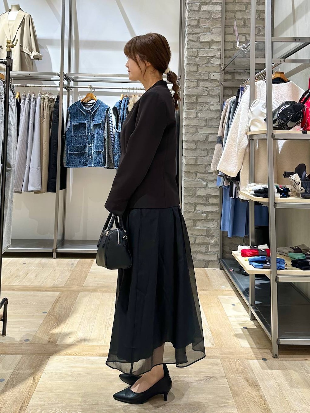 ブラック系のスカート、ブラック系のスーツジャケット、ホワイト系のTシャツ/カットソーを着用したレディースの冬コーディネートの3枚目の写真