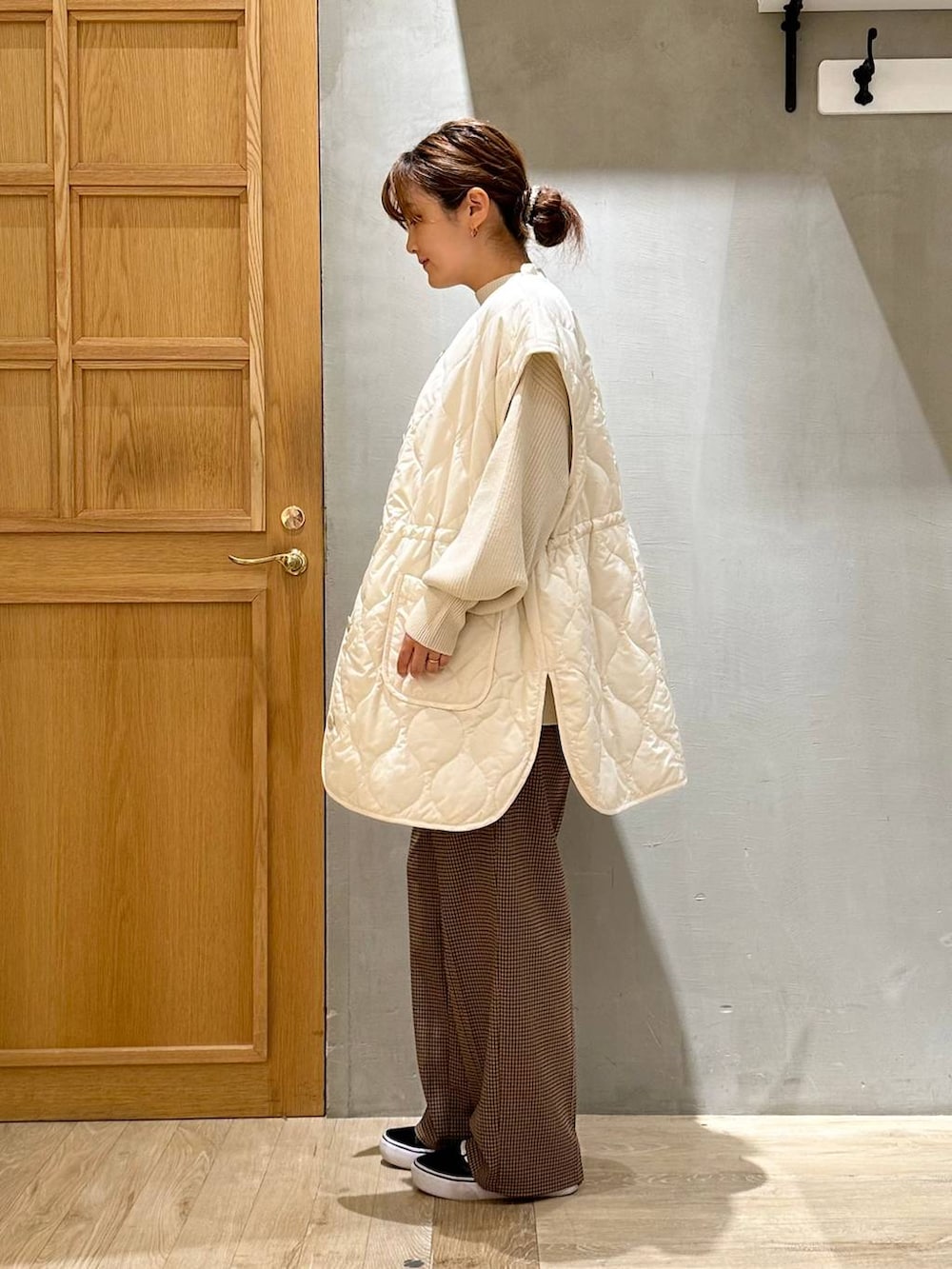 ホワイト系のニット/セーター、ブラック系のショルダーバッグ、ホワイト系のその他アウターを着用したレディースの秋コーディネートの2枚目の写真