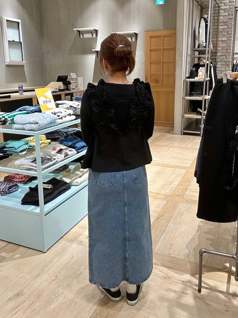 ブラック系のTシャツ/カットソー、ブルー系のデニムスカート、ブラック系のショルダーバッグを着用したレディースの春コーディネートの3枚目の写真