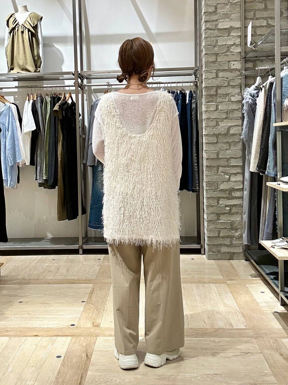 ベージュ系のその他パンツ、ホワイト系のチュニック、ベージュ系のスニーカーを着用したレディースの春コーディネートの3枚目の写真