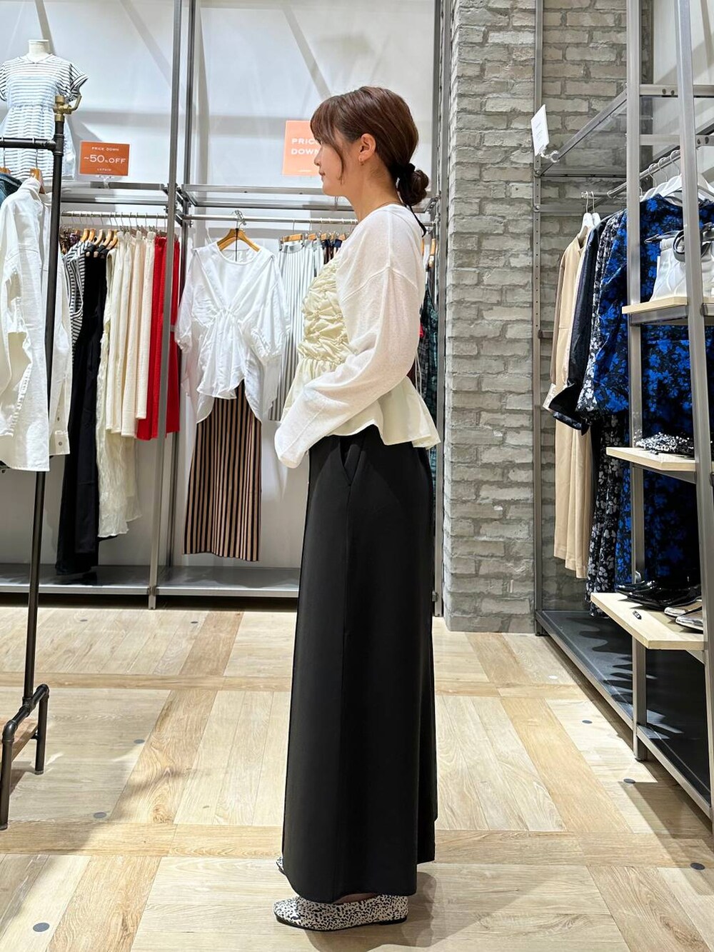 ホワイト系のTシャツ/カットソー、ブラック系のボストンバッグ、ホワイト系のパンプスを着用したレディースの夏コーディネートの3枚目の写真