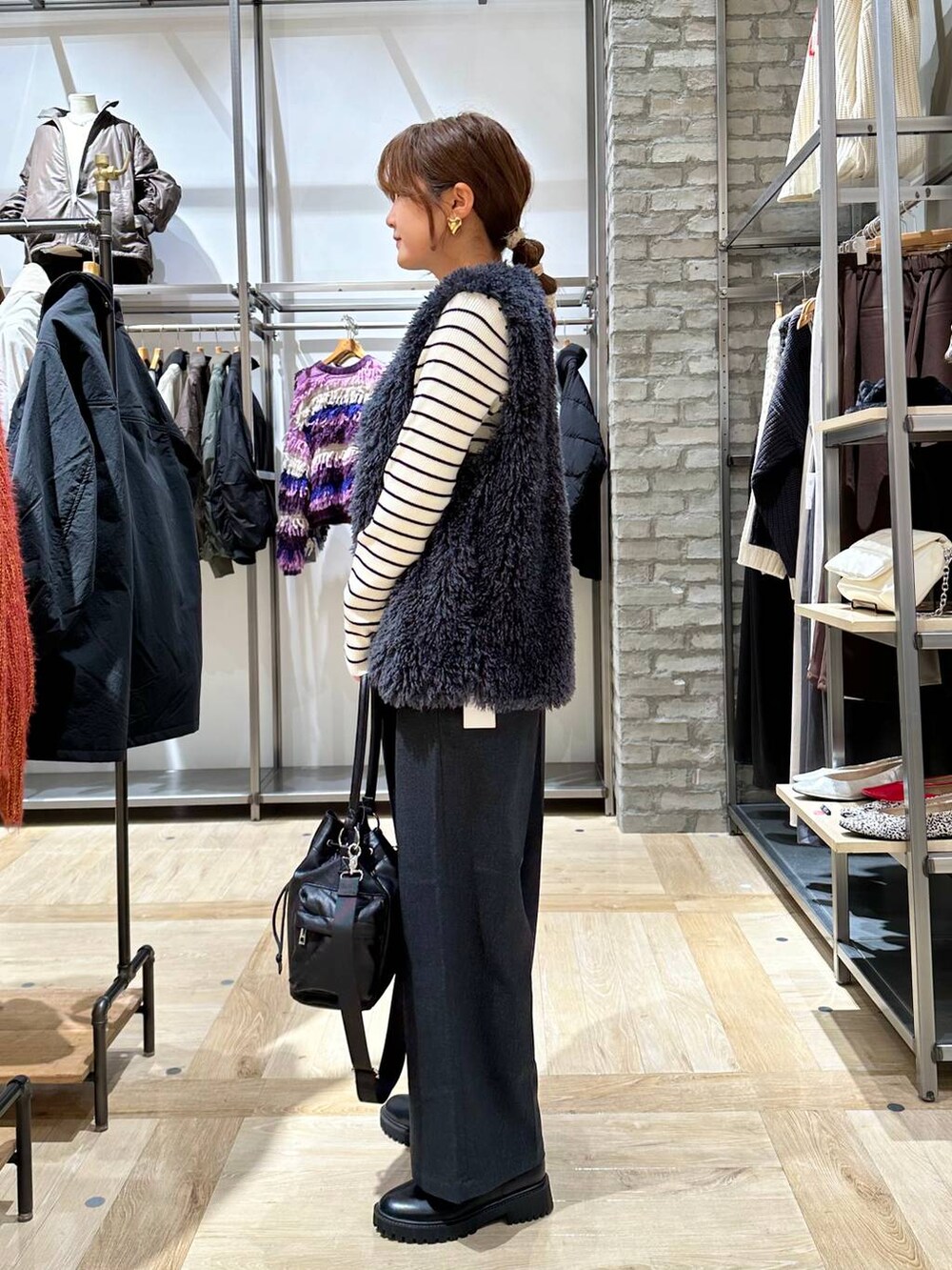 ブラック系のブーツ、ホワイト系のニット/セーター、ブラック系のショルダーバッグを着用したレディースの秋コーディネートの3枚目の写真