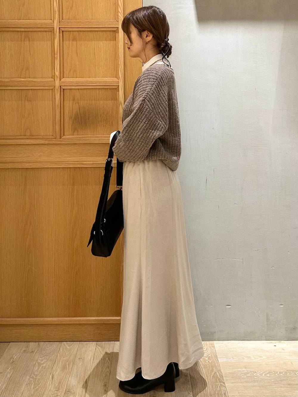 ホワイト系のTシャツ/カットソー、ブラック系のショルダーバッグ、ブラック系のブーツを着用したレディースの冬コーディネートの2枚目の写真