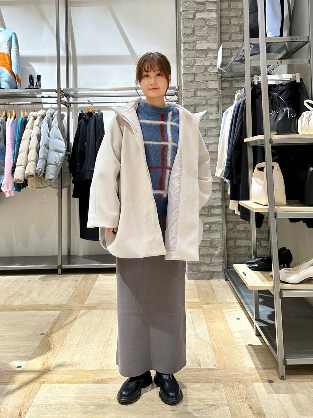 ブラック系のショルダーバッグ、グレー系のスカート、ブラック系のブーツを着用したレディースの冬コーディネートの4枚目の写真