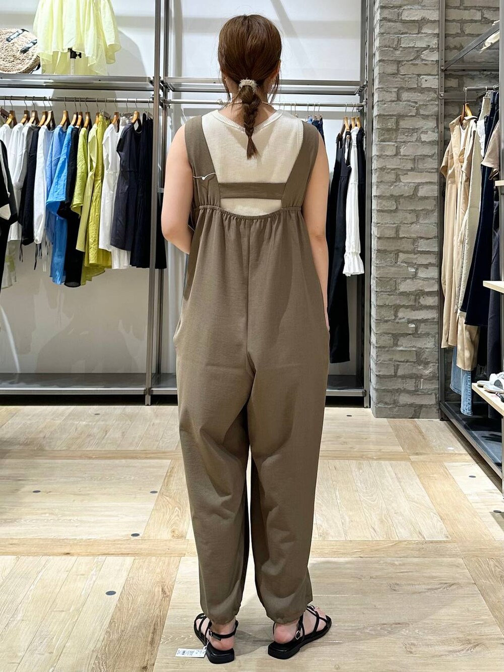 ホワイト系のタンクトップ、イエロー系のつなぎ/オールインワン、ブラック系のサンダルを着用したレディースの夏コーディネートの4枚目の写真