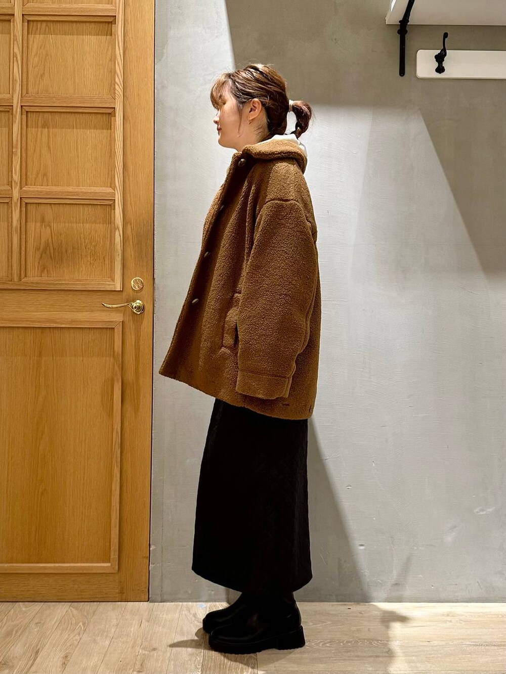 ホワイト系のパーカー、ブラック系のショルダーバッグ、ブラック系のスカートを着用したレディースの秋コーディネートの3枚目の写真