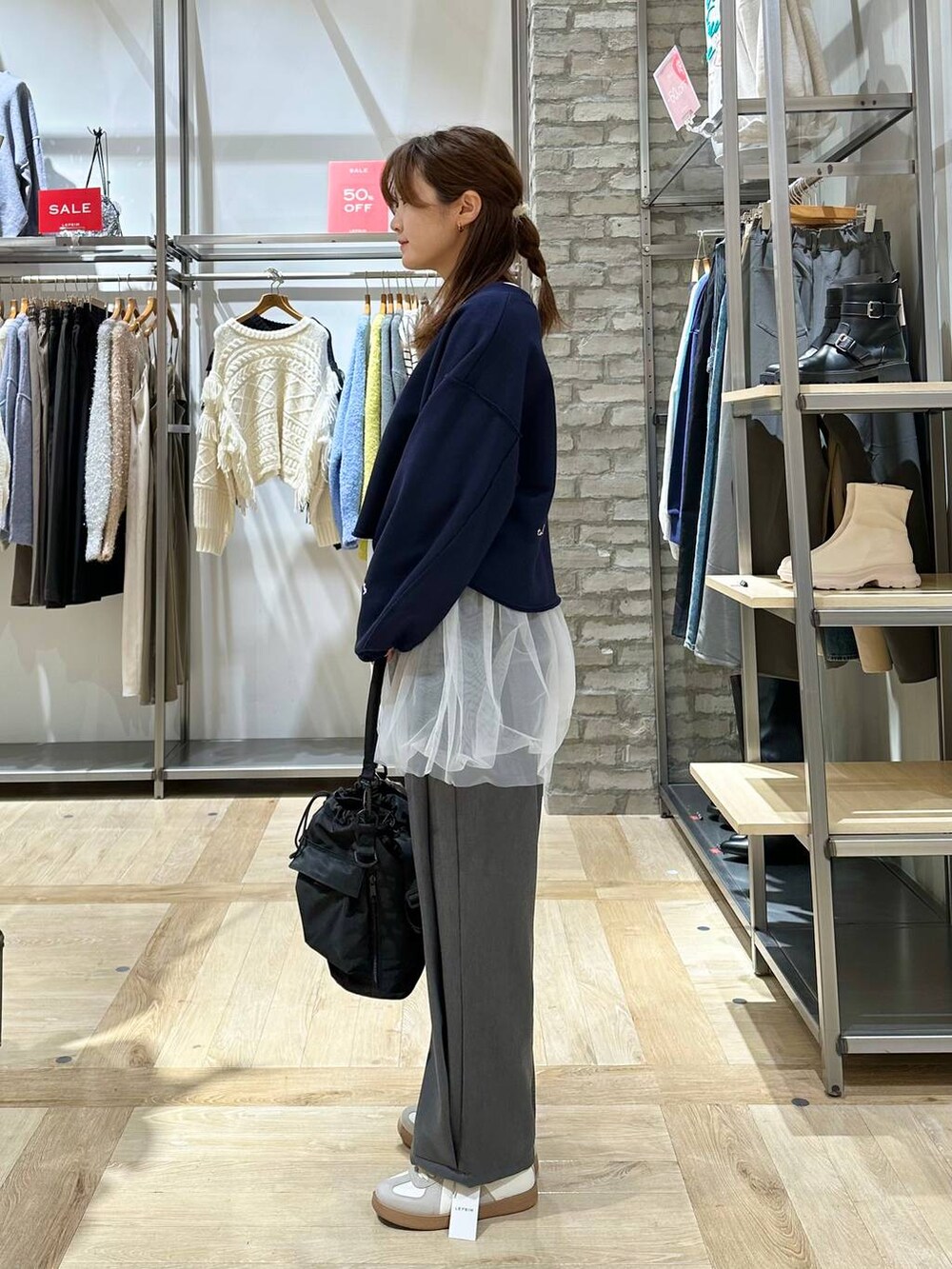 ブラック系のショルダーバッグ、ホワイト系のTシャツ/カットソー、グレー系のその他パンツを着用したレディースの冬コーディネートの2枚目の写真