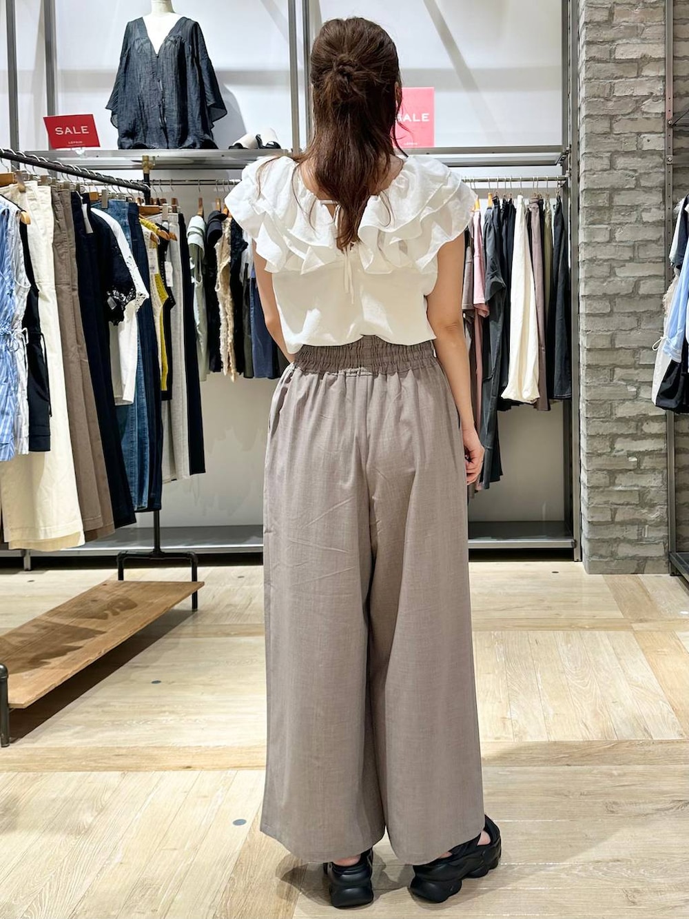 ベージュ系のその他パンツ、ブラック系のサンダル、ブラック系のハンドバッグを着用したレディースの夏コーディネートの3枚目の写真