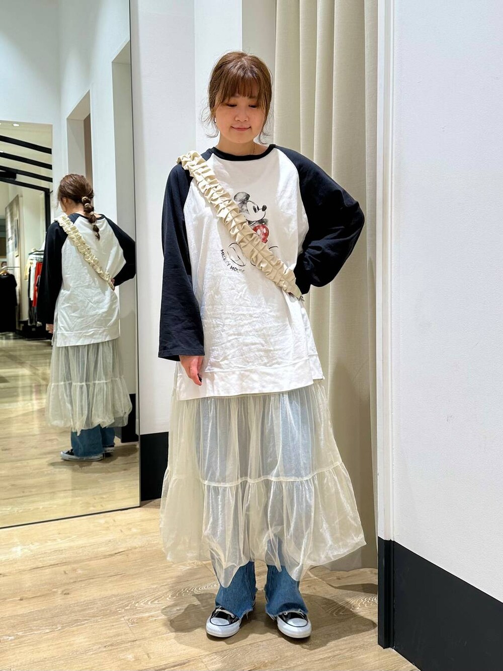 ホワイト系のスカート、ブラック系のTシャツ/カットソー、ブルー系のデニムパンツを着用したレディースの春コーディネートの3枚目の写真