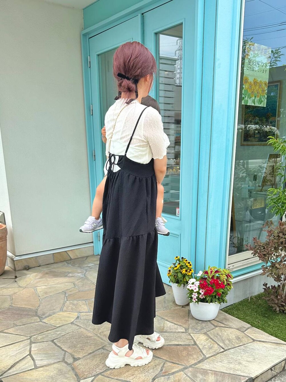 ブラック系のワンピース、ホワイト系のショルダーバッグ、ホワイト系のサンダルを着用したレディースの夏コーディネートの4枚目の写真