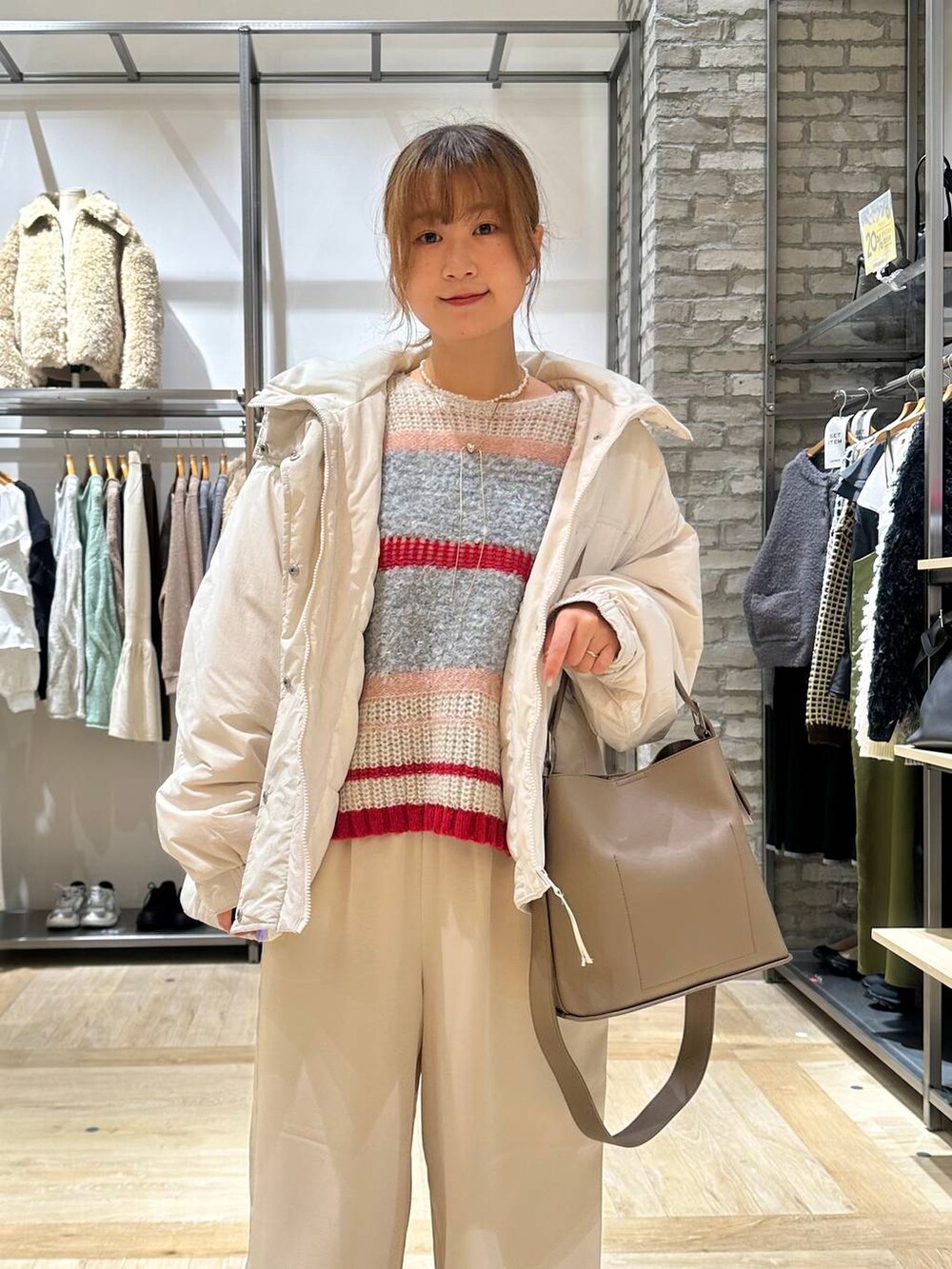 ベージュ系のその他アウター、ホワイト系のその他パンツ、ブラウン系のショルダーバッグを着用したレディースの秋コーディネートの4枚目の写真