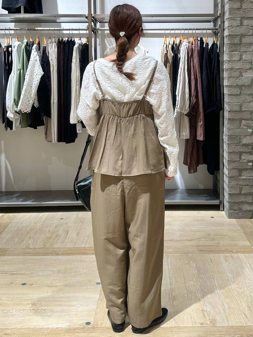 ブラック系のショルダーバッグ、ホワイト系のTシャツ/カットソー、ブラック系のパンプスを着用したレディースの春コーディネートの3枚目の写真