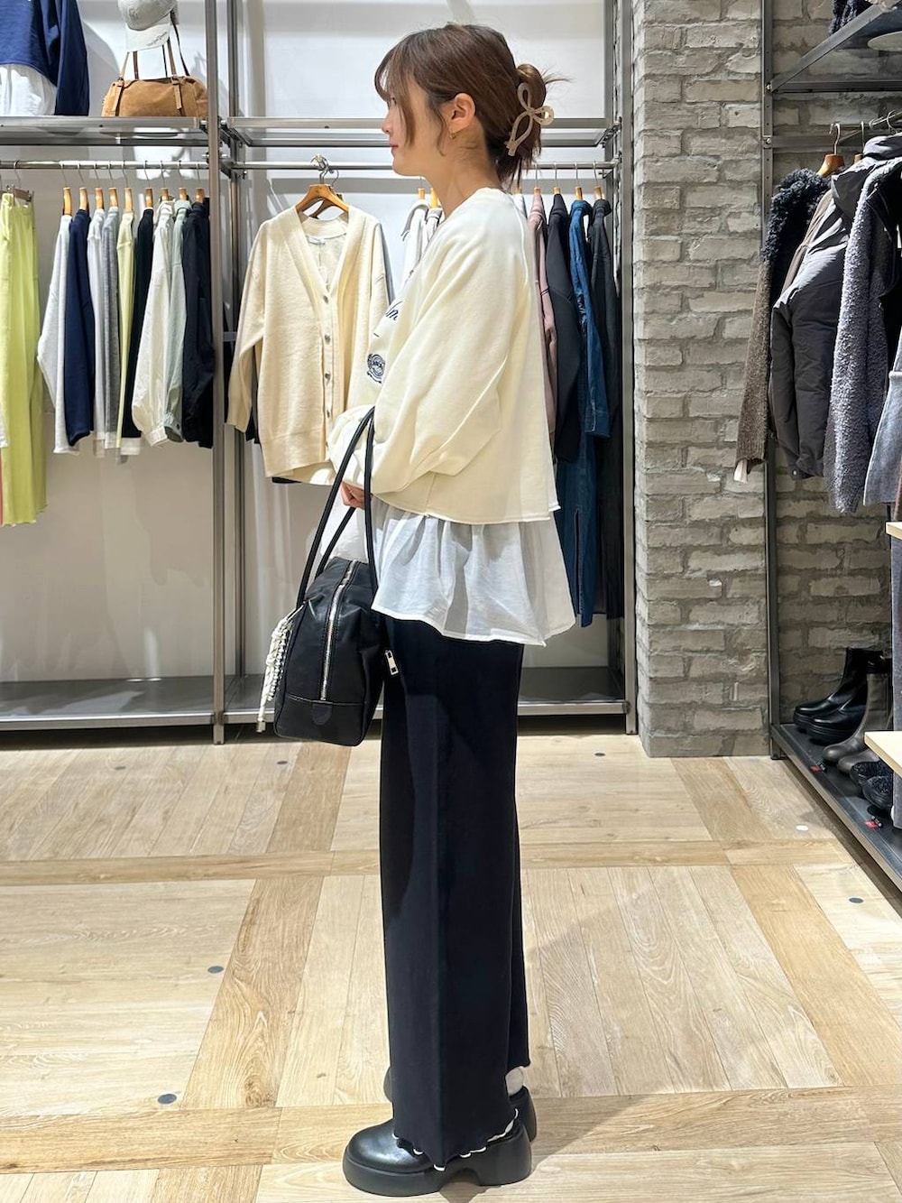 ブラック系のサンダル、ホワイト系のTシャツ/カットソー、ブラック系のボストンバッグを着用したレディースの冬コーディネートの2枚目の写真